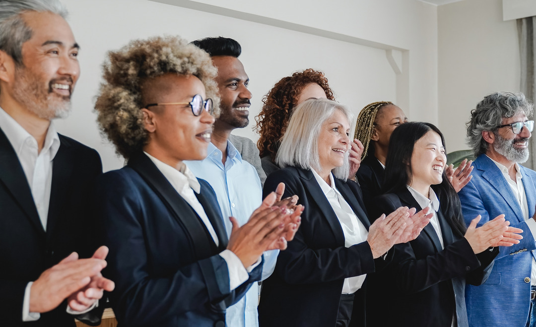 multiracial group of people in an office celebrating success