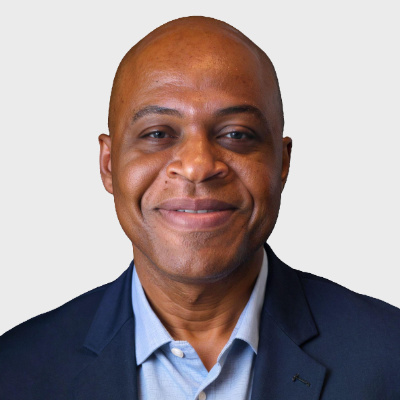 Head and shoulder portrait of Ambrose Turkson Jr a African American middle-aged  bald smiling man in a blue business suit.